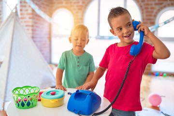 Adorable toddlers playing around lots of toys at kindergarten