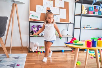 Young beautiful blonde girl kid enjoying play school with toys at kindergarten, smiling happy playing at home