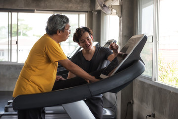 Fototapeta na wymiar Old man cadio on treadmill with trainer