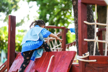 Cute girl climb on wooden playground