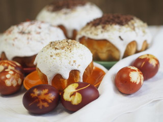 Easter. Traditional Easter pastries and painted onion peeled eggs on a natural tablecloth. Wooden ancient background. We celebrate the holiday. Sprinkled with natural ingredients.