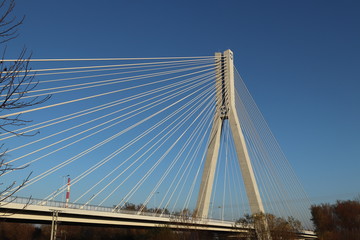 Rzeszow, Poland - 9 9 2018: Suspended road bridge across the Wislok River. Metal construction technological structure. Modern architecture. A white cross on a blue background is a symbol of the city