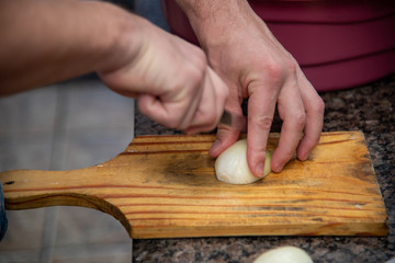 Slicing onion on wooden board