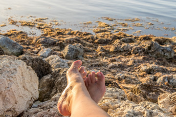 feet crossed relaxing at the shore