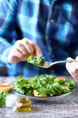 Chef preparing a healthy salad. Male hand mixed salad with mozzarella and tangerine. Salad a la caprese with corn salad and mandarin.