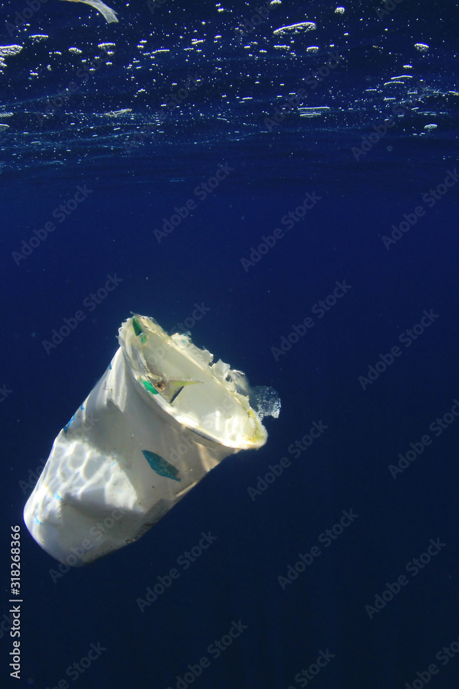 Poster plastic cup drifting in ocean. underwater plastic pollution