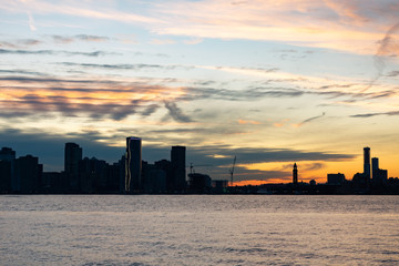 Fototapeta na wymiar Silhouette of the Jersey City Skyline along the Hudson River during a Beautiful Sunset