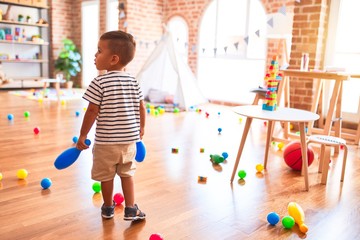 Beautiful toddler boy playing bowling at kindergarten