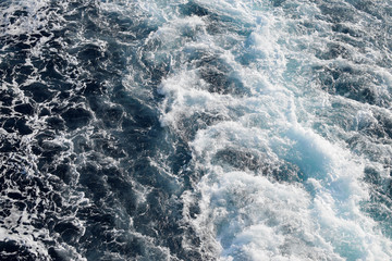 Fototapeta na wymiar Foam on the sea top view background. a beautiful rail on the sea or ocean surface behind of speed cruise liner. Wake in the ocean made by large ship.
