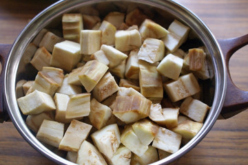 Sliced eggplant in a saucepan top view. Raw eggplant peeled and diced, cooking eggplant dishes.