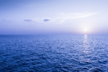 Watercolor blue sunset over the blue ocean.