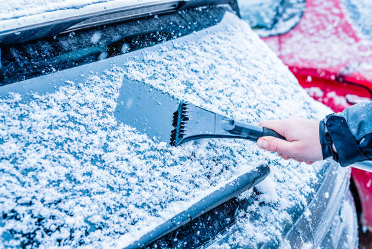 Guy clean back car window with ice remover tool