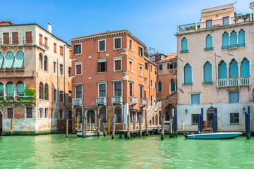 Fototapeta na wymiar Venice, Italy. View of Venice from the Grand Canal. Venetian old colorful buildings against blue sky and white clouds. Boat trip through the canals of Venice. Vacation in Europe concept.