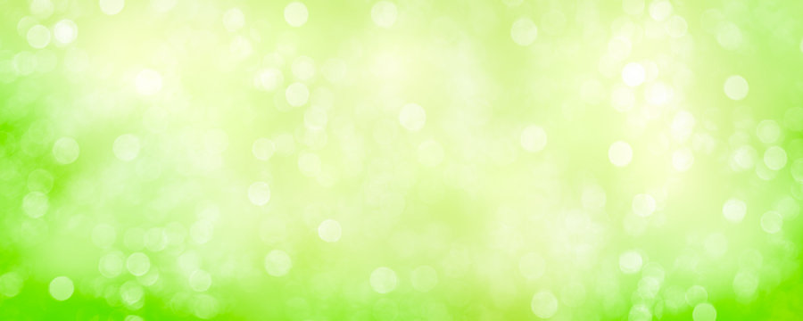 Spring background with green blurred bokeh lights.