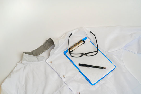 Simple Classic White Doctor Uniform Clothes And Eyeglasses Flat Lay On The Table