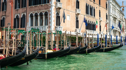 Fototapeta na wymiar Venice, Italy. View of Venice from the Grand Canal. Venetian Gondolas. Old colorful buildings in Venice. Jetty. Boat trip through the canals of Venice. Vacation in Europe concept. Italian Landmarks.