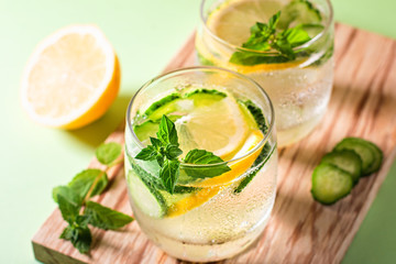 Healthy refreshing summer cocktail or mocktail without alcohol with lemon and cucumber. Summer detox drink on fresh green background, healthy living, top view