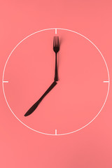 a simple abstract painted clock made of plastic fork and knife, creative idea of zero waste concept