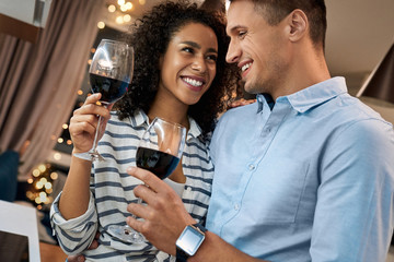 Young adult multicultural couple drinking wine, spending evening together