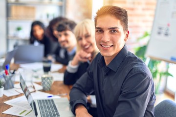 Group of business workers sitting in line with smile on face. Looking at the camera, young man smiling at the office