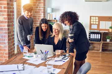 Group of business workers smiling happy and confident. Working together with smile on face  using laptop at the office