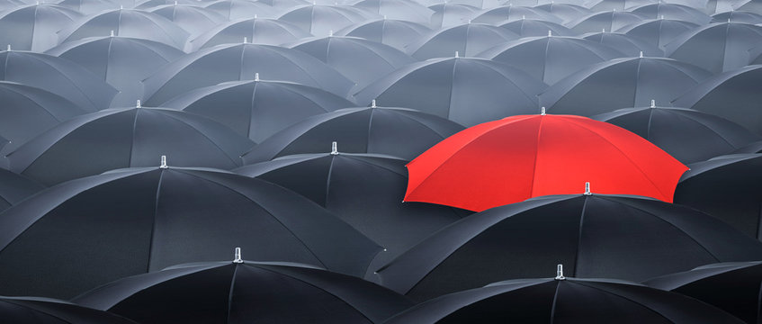 Different and standing out of the crowd umbrella. Concept of leader.