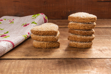 Heart shaped shortbread cookies on a wooden table. Nearby lies a tissue napkin.