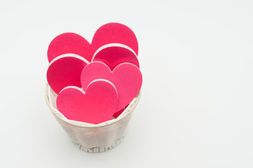 White basket with several red and pink hearts isolated on white background. Celebration for Valentine's Day. Copy space. Horizontal shot.