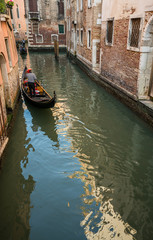 gondola cruises through canal in Venice, Italy.