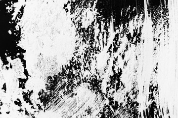 Patterns of white paint from a brush on a black background.