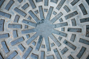 Closeup of manhole cover or pipe cap on the footpath,abstract wallpaper.