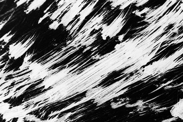 Patterns of white paint from a brush on a black background