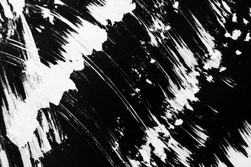 Patterns of white paint from a brush on a black background
