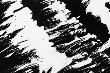 Patterns of white paint from a brush on a black background