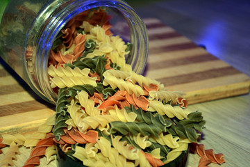 Multi-colored pasta on a wooden board. Food.