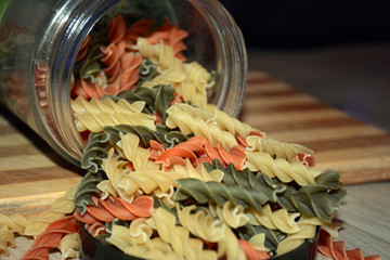 Multi-colored pasta on a wooden board. Food.
