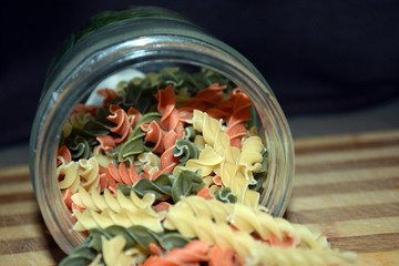 Multi-colored pasta on a wooden board. Food.