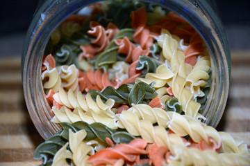 Multi-colored pasta on a wooden board. Food.