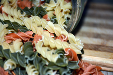 Multi-colored pasta on a wooden board. Food.