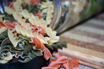 Multi-colored pasta on a wooden board. Food.
