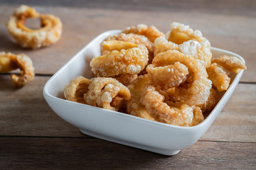Pork rind, pork crackling in white bowl.