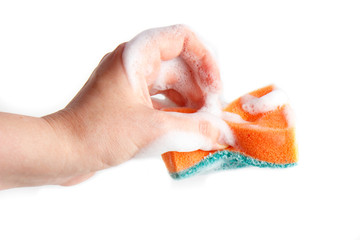 Hand compresses a soapy sponge for washing dishes on a white background