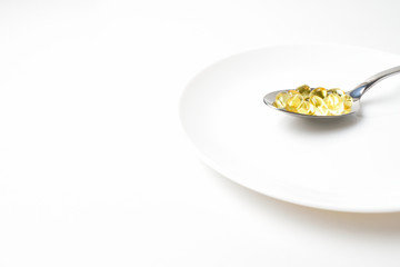Fish oil capsules in the spoon.