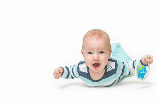 Front view of baby boy lying on white background holding a toy and looking at the camera. Photo contains a lot of free space for your use. All potential trademarks are removed. 