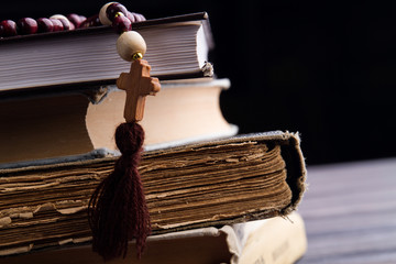 Obraz premium Close-up wooden cross and old books stack. Learning God's word.