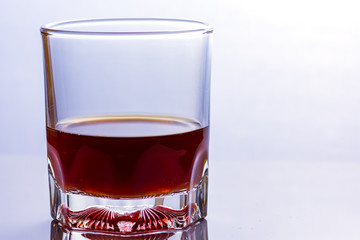 Glass of whiskey on a glass table.