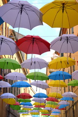 Fototapeta na wymiar Bunte Regenschirme in Reihen über einer Straße aufgespannt