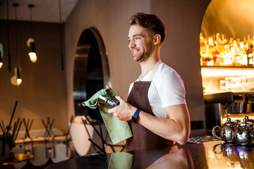 Smiling Caucasian waiter posing for camera indoors