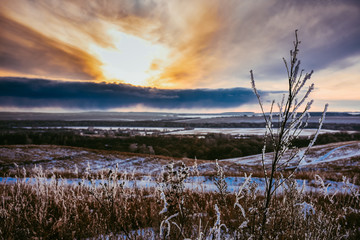 Colorful sunset in the field, winter sunset, orange bright sunset in the winter field