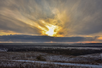 Colorful sunset in the field, winter sunset, orange bright sunset in the winter field